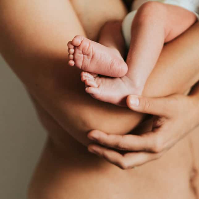 frau mit baby am arm als bild für haut